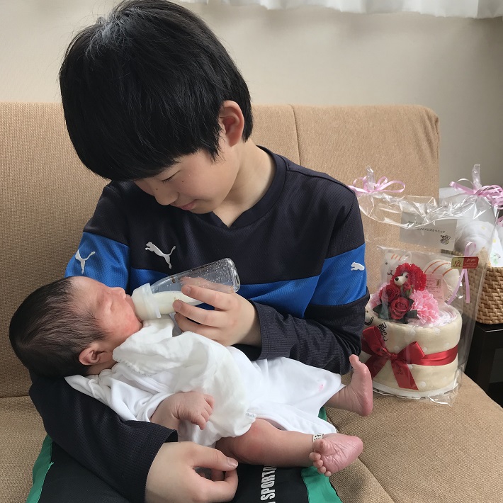 赤ちゃんにミルクをあげるお兄ちゃん