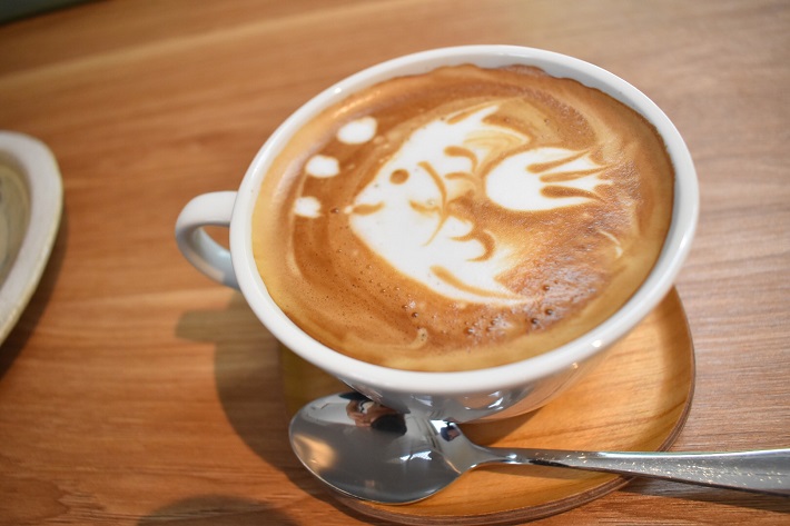 かわいい魚のラテアートがあしらわれたちいさな箱カフェのカフェラテ